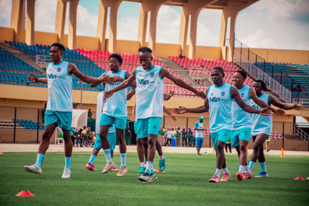 Niger Tornadoes players warming up together on the pitch