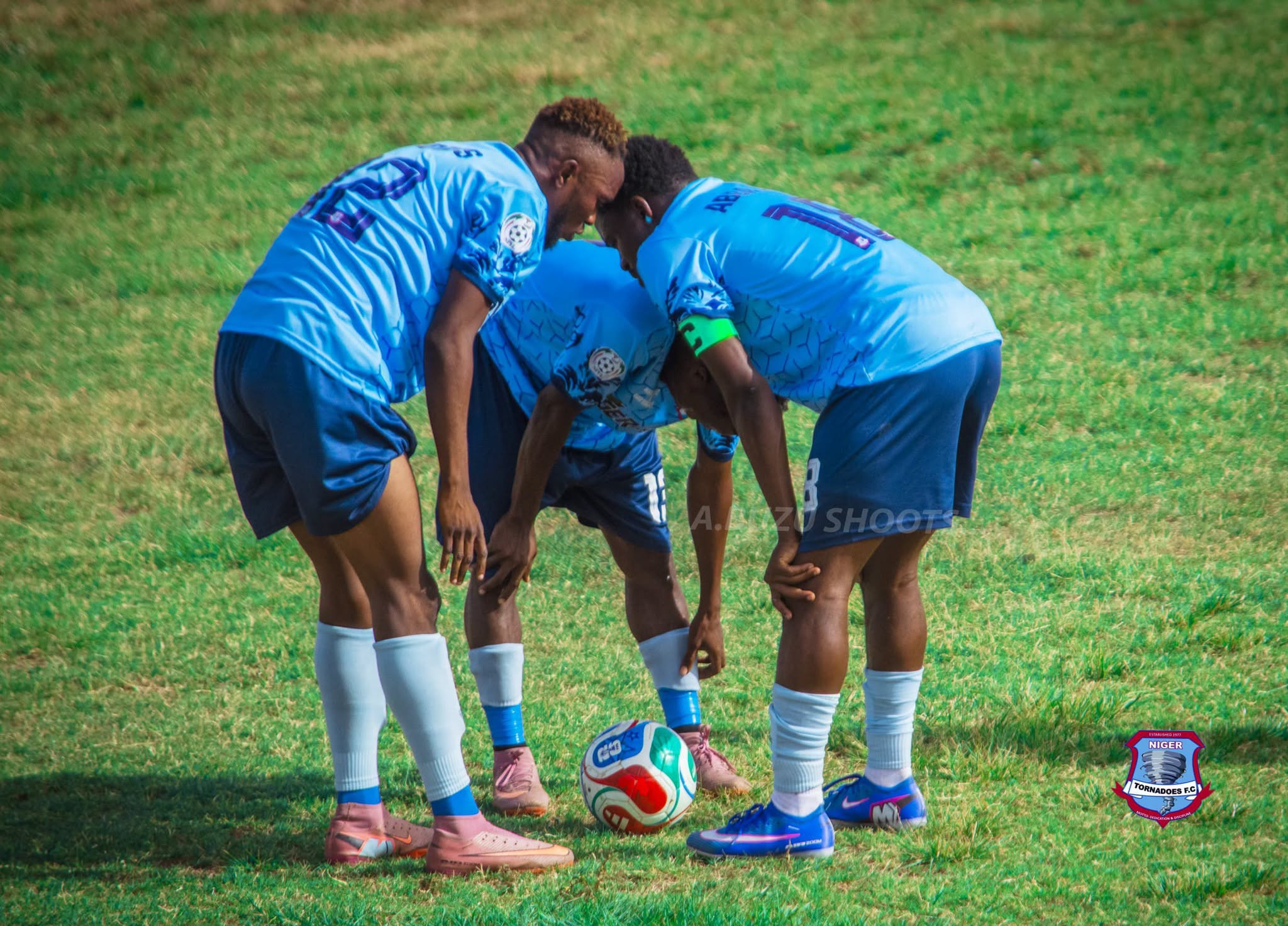 Players huddle over the ball before a set piece